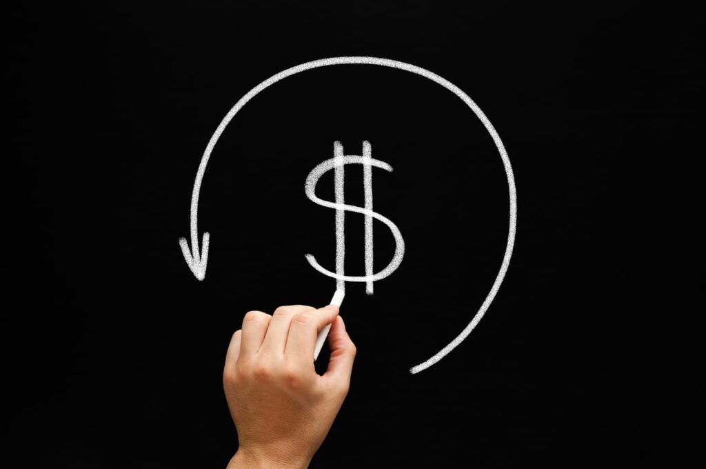 pessoa desenhando um símbolo que representa a devolução de dinheiro em um pedido de chargeback